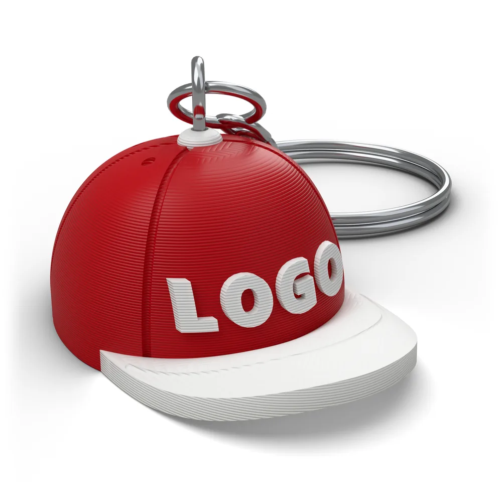 Red Cap Keychain render: a mini snapback with LOGO raised on the crown, a white brim and the metal key ring